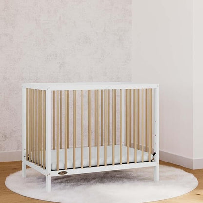 Graco Teddi 4-in-1 Convertible Mini Crib with Bonus Water-Resistant Mattress (White with Driftwood) – GREENGUARD Gold Certified, 2.75-Inch Mattress Included, Convenient Size, Easy 30-Minute Assembly